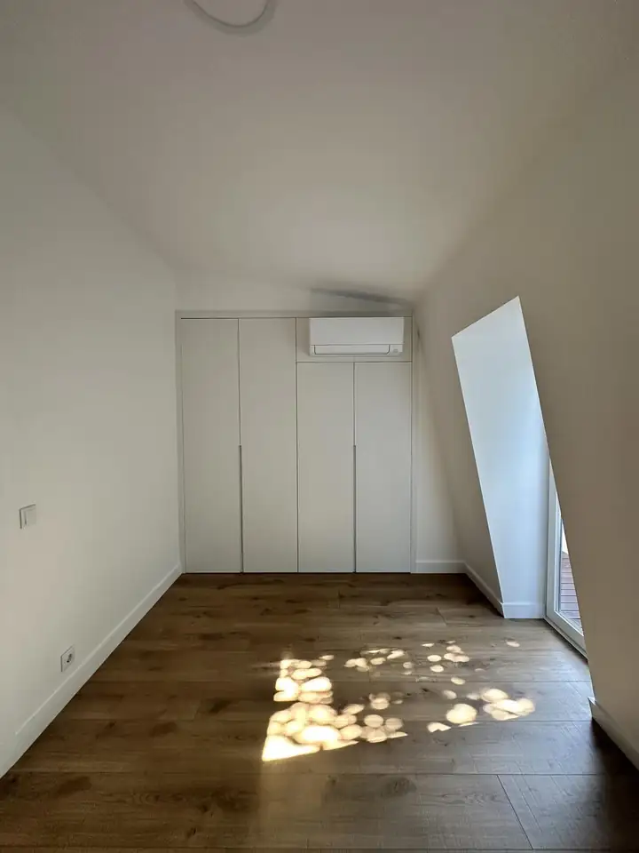 Attic bedroom conversion with fitted wardrobes under a renovated Porto roof