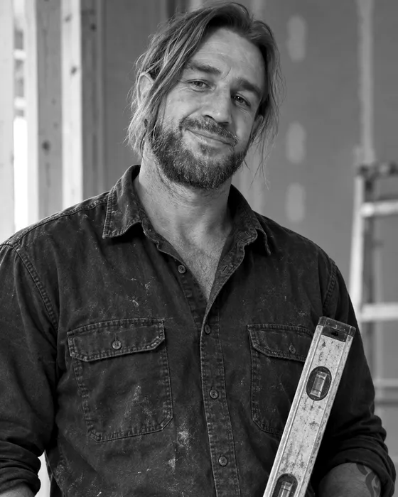 Bradley Cahill on site holding a spirit level