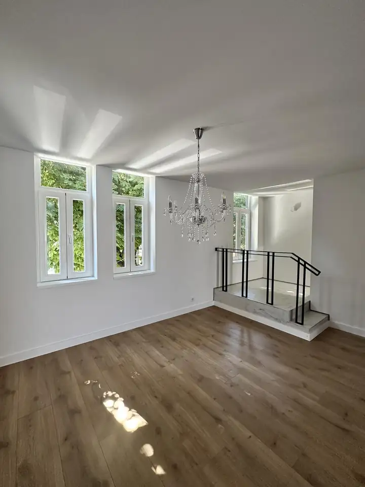 Finished living room in a Porto renovation with restored timber casement windows and oak flooring