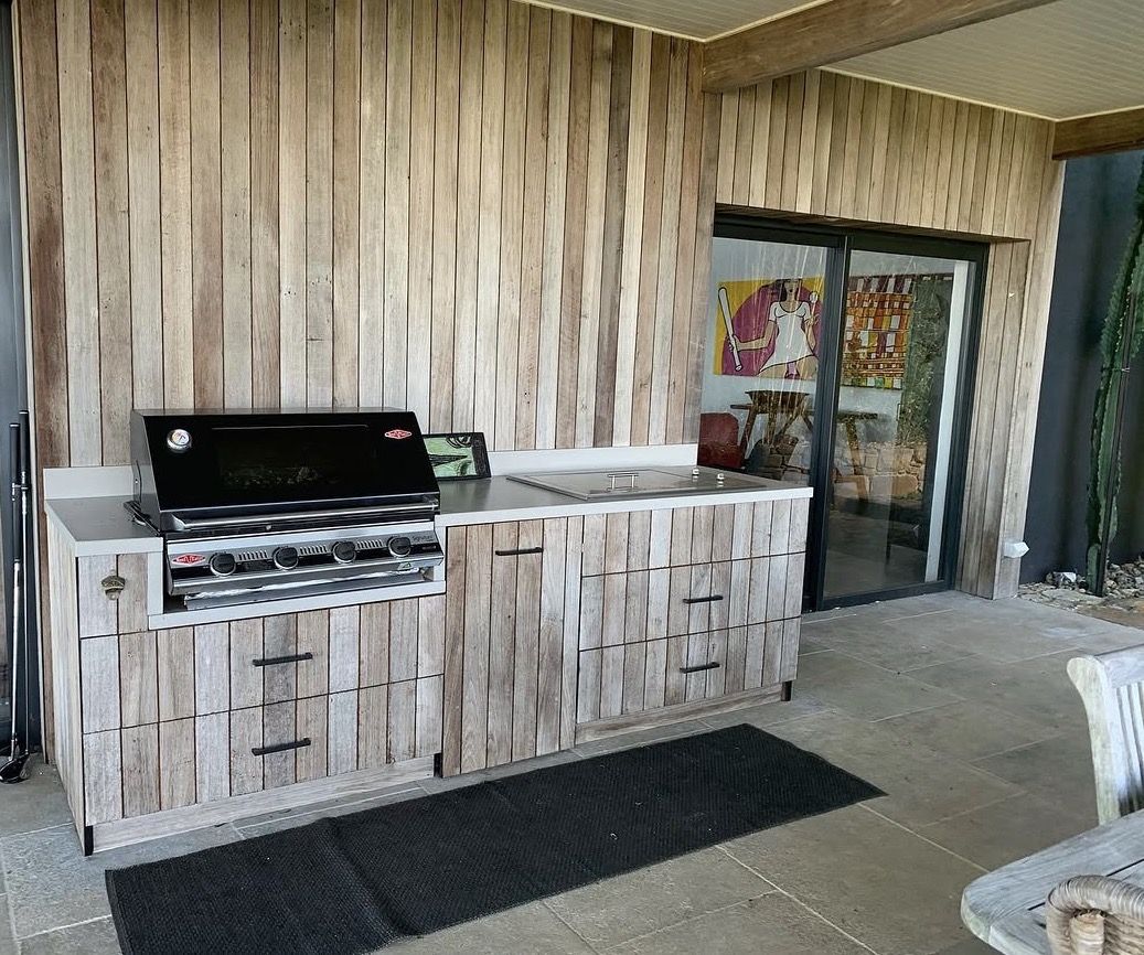Cozinha exterior construída em madeira maciça reciclada
