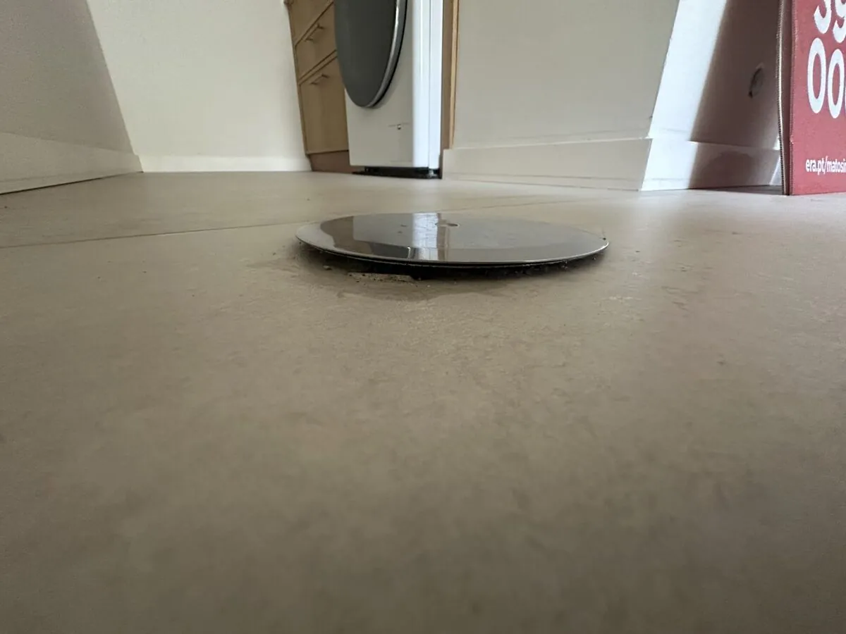 Drainage access cover sitting proud of a tiled floor