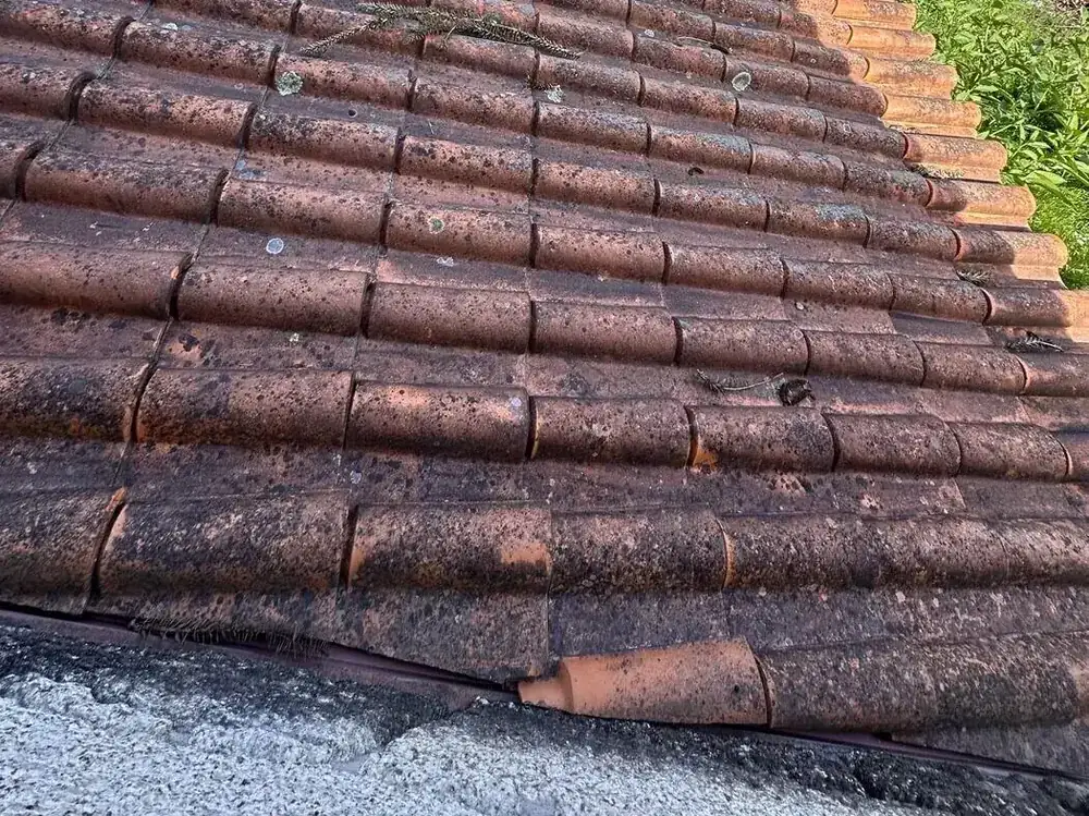 Beirado de telha cerâmica numa casa de granito sem caleira e com uma telha partida na borda