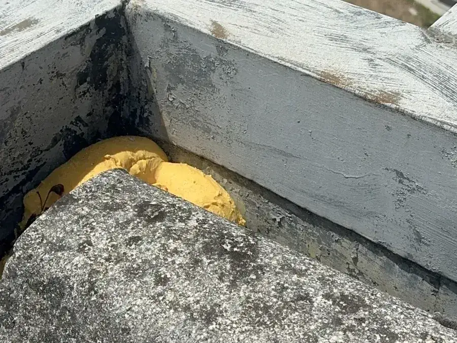Espuma expansiva aplicada numa caleira embutida de um telhado de fibrocimento