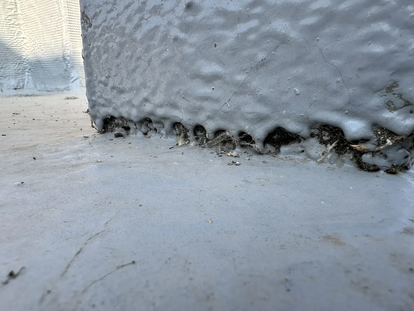 Liquid roof membrane debonding with open voids at the base of an upstand