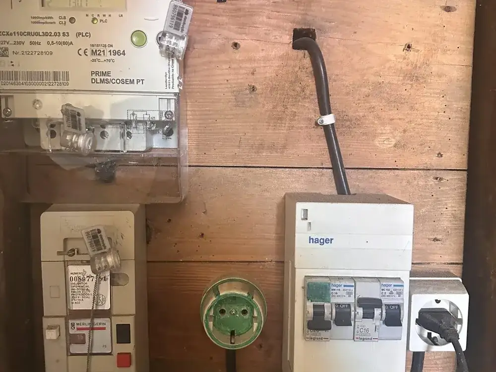 Old electrical meter cabinet with a dated differential switch on bare plywood