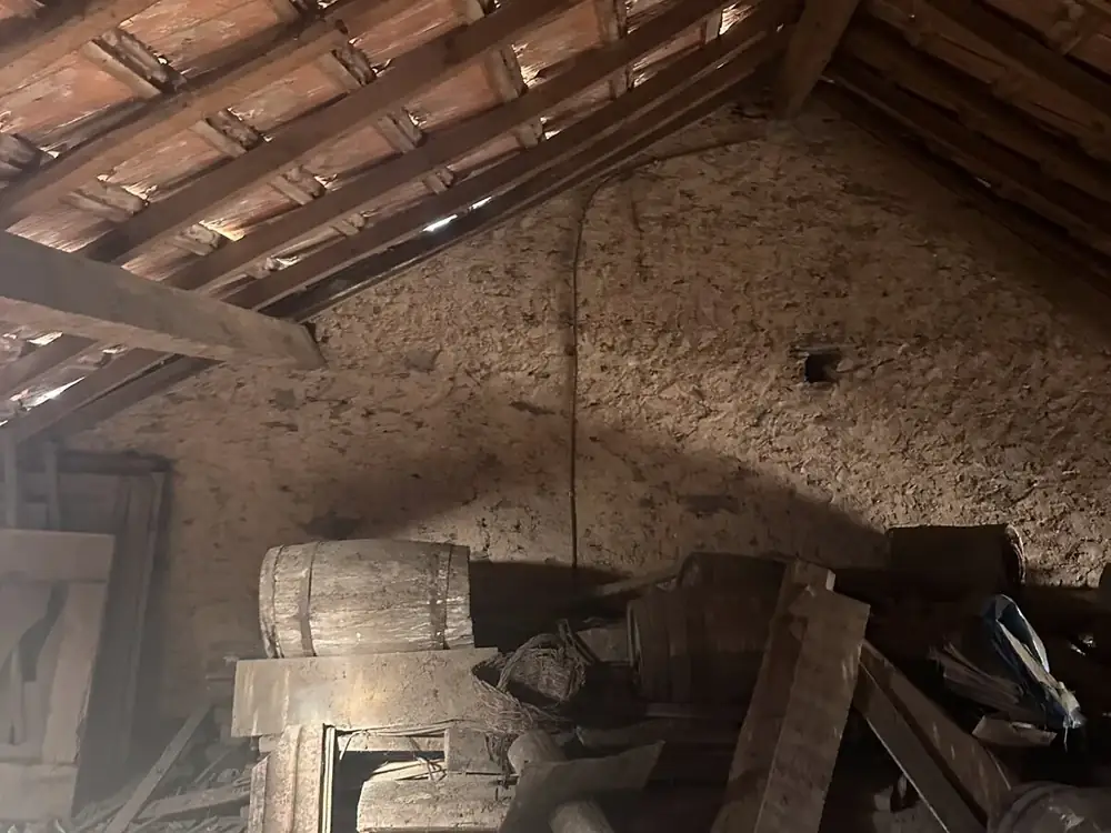 Old roof space with clay tiles laid straight on battens over timber rafters