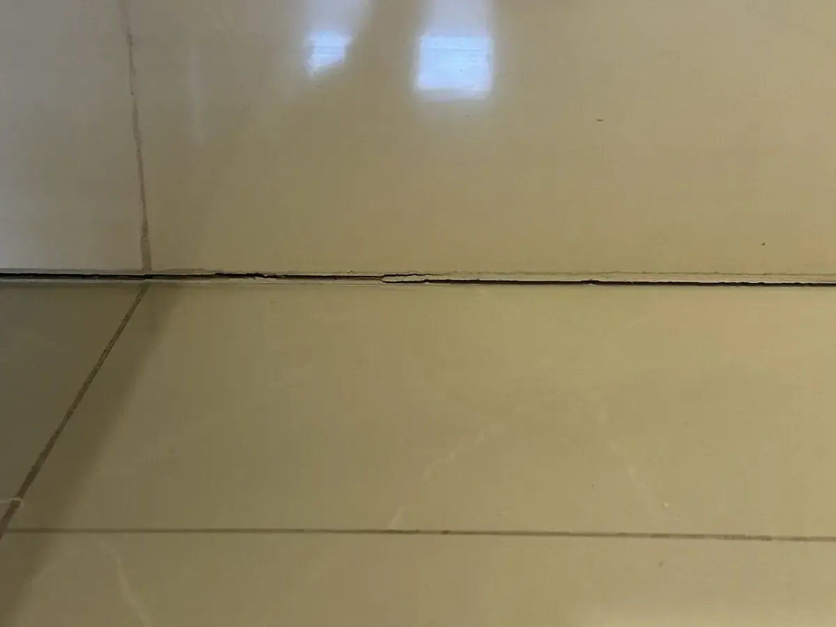 Open joint between floor and wall tiles in a shower room