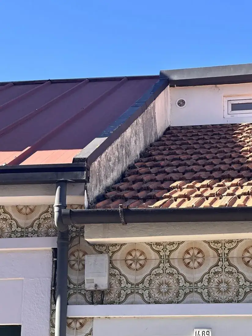 Roof abutting a neighbouring parapet with a mortar fillet and no flashing
