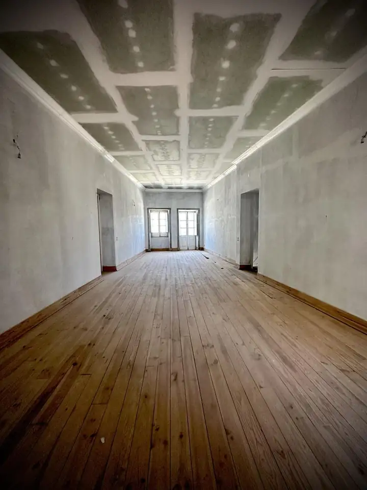 Porto townhouse renovation in progress with restored panelled ceiling and original pine floorboards
